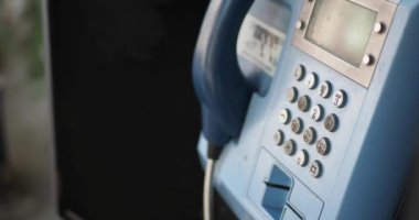 Elektrikli mavi bir iletişim cihazına yakın çekim, bir ankesörlü telefon.
