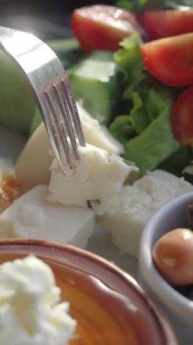 Yemek tabağı dolusu peynir ve marul kareli masa örtüsü..