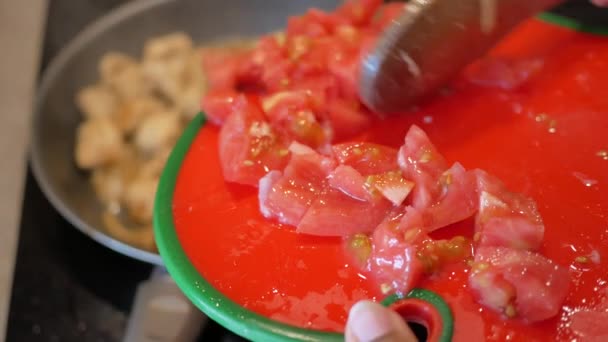 新鲜切碎的西红柿加到热腾腾的锅里做好吃的菜 — 图库视频影像