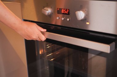 Mutfakta el fırın kapısı açılıyor.