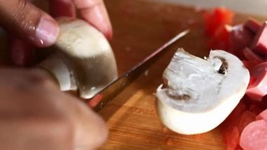 Taze şampiyon mantarını doğrama tahtasıyla kesiyorum. .