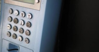 Elektrikli mavi bir iletişim cihazına yakın çekim, bir ankesörlü telefon.