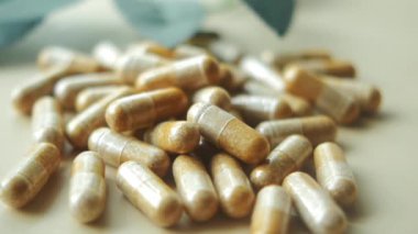  Bitkisel ilaç kapsülü masaya düşüyor. ,