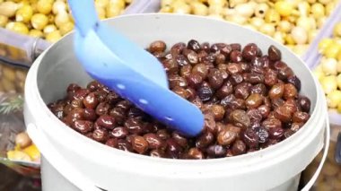 Kavanozda kaşık ile siyah zeytin dilimler.
