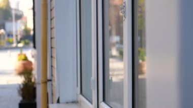 Dinamik bir video kentsel manzaraları pencerelerdeki yansımalardan yakalıyor, binaların ve mağazaların önündeki insanları yoldan geçen araçları ve caddeleri gözleriyle gösteriyor.