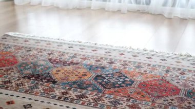 Aynanın yanındaki zeminde desenli bir halı duruyor..
