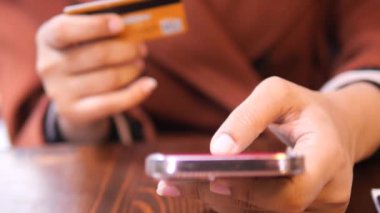  Kadınlar ellerinde kredi kartıyla internet üzerinden akıllı telefon alışverişi yapıyorlar..