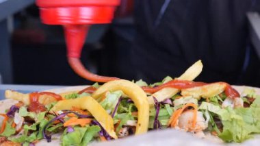 Tavuklu dürüm üzerine domates sosu ve mayonez döküyorum. ,