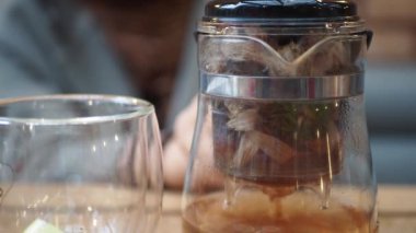 Evde çay servisi için kahve makinesi, bardak ve kaşık ile sofra takımı.,