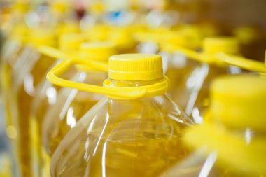 Sarı ayçiçeği yağı şişesi bir mağazada dizilmiş. .