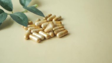 Bitkisel ilaç kapsülünün beyaza düşüşünün üst görüntüsü ,