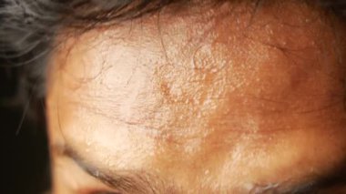 Alnındaki terin koyu arkaplana yakın çekimi 