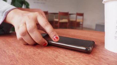 Kadın eli, telefon almak için akıllı cep telefonunu kaldırıyor. .