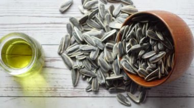 Ayçiçeği yağı tohumu ve yağ bir kabın içinde masanın üstünde ,