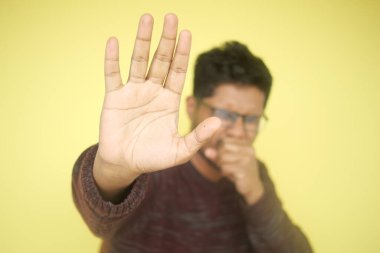 Hasta adamın grip alerjisi var. Hapşırıyor ve burnunu siliyor.