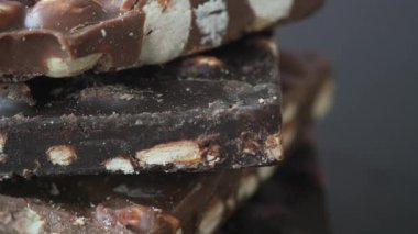 Siyah arka planda karışık fındıklı koyu çikolata .