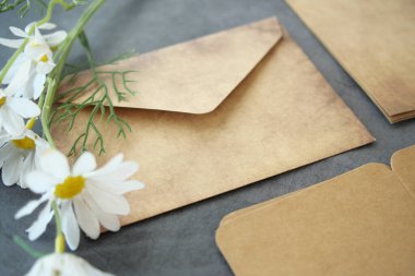 Zarf, boş kağıt ve masada bir çiçek. .