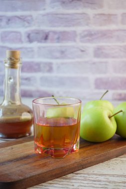 Cam şişede elma sirkesi ve masada taze yeşil elma. ,