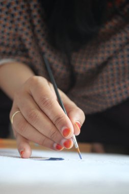 Kadınlar fırçayı boyayla tutarlar. .
