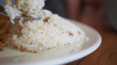 Beyaz pirinç ve patates kızartması bir tabakta çatalla, yemek düzeninde, yemek için hazır.