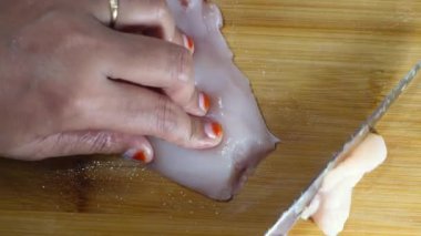 Tavuk filetosunu doğrama tahtasıyla kesiyorum. ,