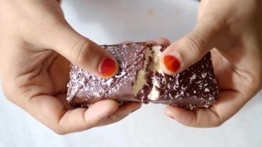 Hindistan cevizi ve çikolatalı protein çubuklarını kıran el görüntüsü. ,
