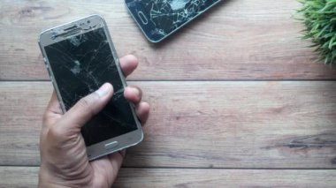 Adamın el ele tutuşmasının en üst görüntüsü kırık akıllı telefon...