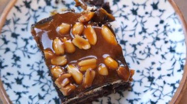 Zarif bir çiçek tabağında servis edilen nefis karamel fındıklı brownie 'nin yakın çekimi..