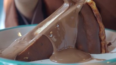 Çikolata sosu ile kaplı bir tabağa konmuş çikolatalı pasta diliminin yakın çekimi.