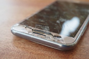 Renk arkaplanındaki bozuk akıllı telefonun üst görünümü.