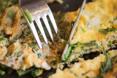 Kadınlar masada yumurtalı omlet yiyor. .