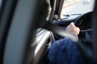 Arka koltuktan bak, ön planda emniyet kemeri olan direksiyona odaklan..