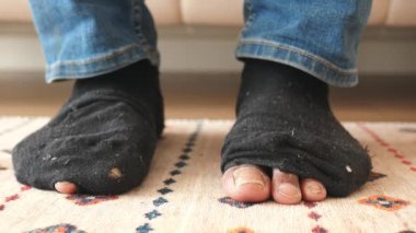 Kanepede otururken kirli çoraplı erkekler .