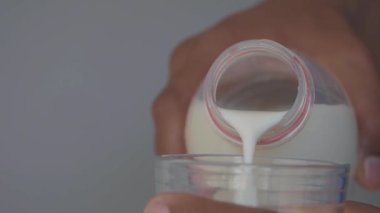  Masadaki bardağa süt dökerek .