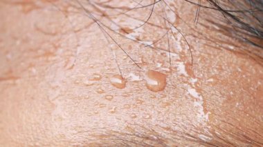 Alnındaki terin koyu arkaplana yakın çekimi 