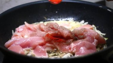 Baharat, soğanlı tavaya çiğ tavuk dilimleri eklenir. Bir dizi fotoğrafta yer alır.