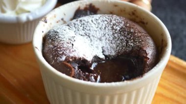 Çikolatalı lava kekinin tadını çıkar, üzerine pudra şekeri serp ve yanında krem şanti ile servis et.