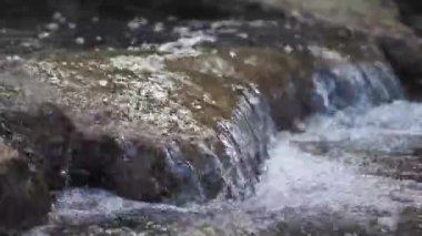 Küçük bir şelaleye yakın. Kayaların üzerinden temiz su akıyor.