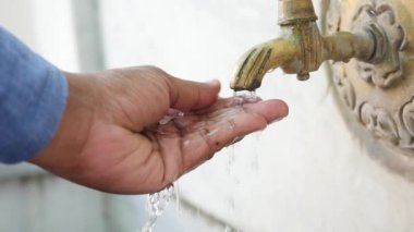 El musluğun altında, su akıyor, parmaklar açık, musluğun altında yıkanıyor..