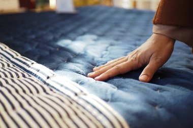 Kadınlar. El, ortopedik yatağa dokunur ve baskı yapar..