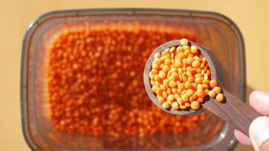Portakallı mercimek ve ahşap kepçeyle dolu, yiyecek stoku fotoğrafçılığı için mükemmel bir kap.