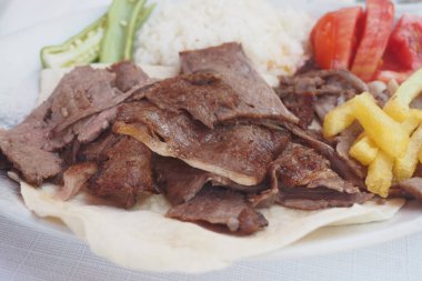Lezzetli donör kebabı pirinçli, domatesli, salatalıklı ve turşulu, öğle ve akşam yemeği için harika.