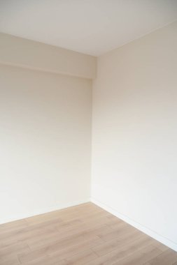 Açık duvarlı ve ahşap döşemeli minimalist bir odada temiz, boş bir köşe..