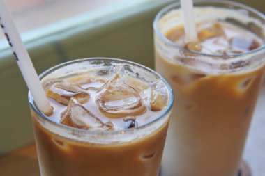 Kafe masasında şeffaf bir bardakta buzlar eridi. ,