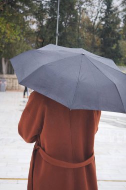 Kadınlar yağmurda şemsiye altında ,