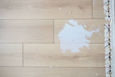 Tahta zemine beyaz süt döküldü.