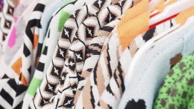 Yakından bakınca çeşitli renkli ve desenli giysilerin askılarda sallandığını görüyoruz.