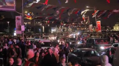 Sokakları dolduran insanlar, arabalar ve bayraklarla dolu bir gece, neşeli bir atmosfer yaratıyor..