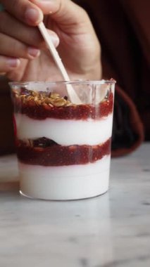 Lezzetli katmanlı yoğurt. Çilekli komposto ve granola. Bardakta servis ediliyor..