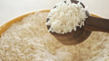 Yavaş yavaş kaşıktan düşen çiğ pirinç. .